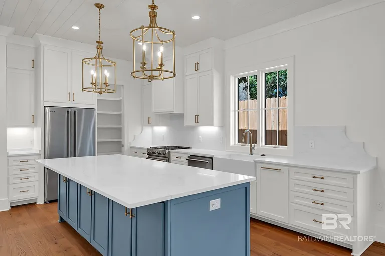 Kitchen island with white countertop and brass pendant lighting at 410 Azalea St #101