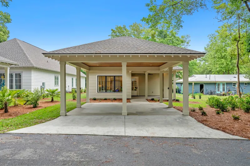 Covered carport beside a cottage with landscaped planting beds