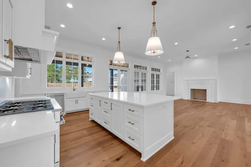 Open kitchen and living space with a white island and wood floors