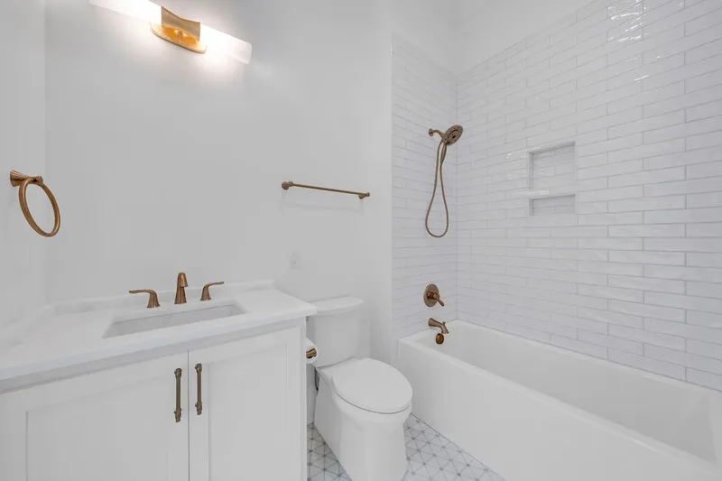 Bathroom with a white vanity and a subway-tiled bathtub surround
