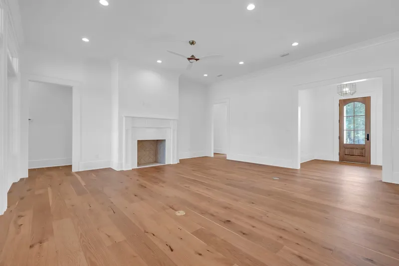 Unfurnished open living area with wood floors and a glazed front door