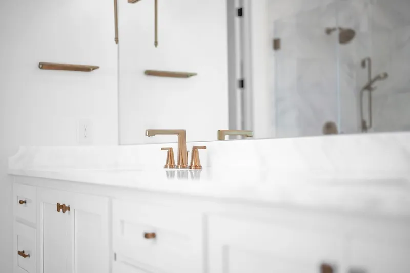 Close-up of a white bathroom vanity with brass-colored fixtures