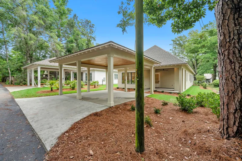 Angled view of a covered carport and driveway beside a cottage
