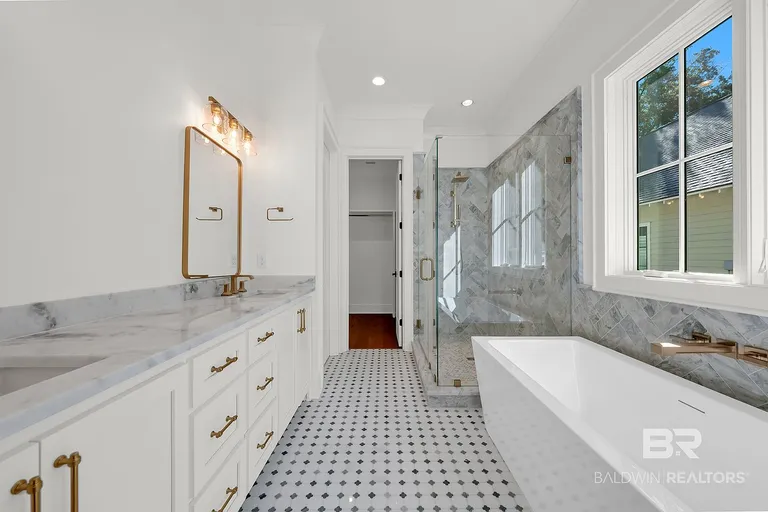 Bathroom with freestanding tub, tiled shower and long vanity at 410 Azalea St #101