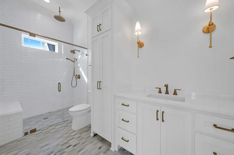Bathroom with a white vanity, tub-shower combination and patterned floor tile