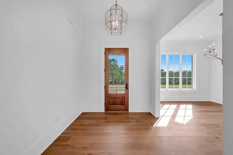 Entry hall with a wood front door, pendant lantern and wood flooring