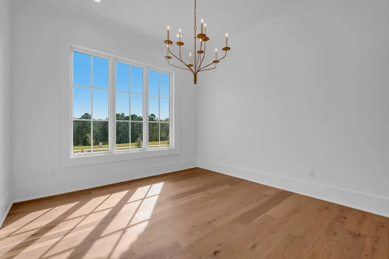 Empty dining room with a chandelier and a large window