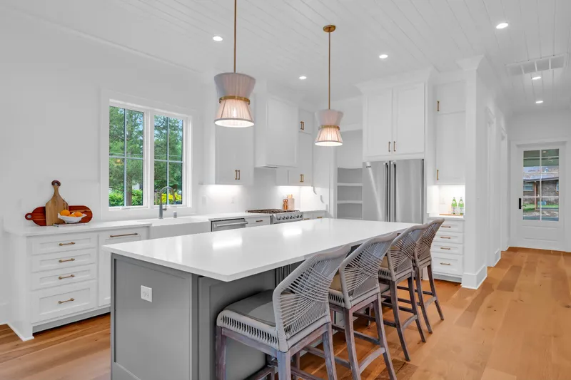 Kitchen island with woven barstools and a view into the dining area