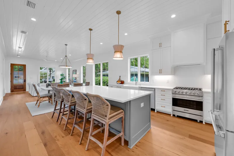 Open kitchen with an island, woven barstools and pendant lights