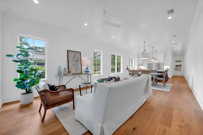 Furnished living room opening into a dining area and white kitchen