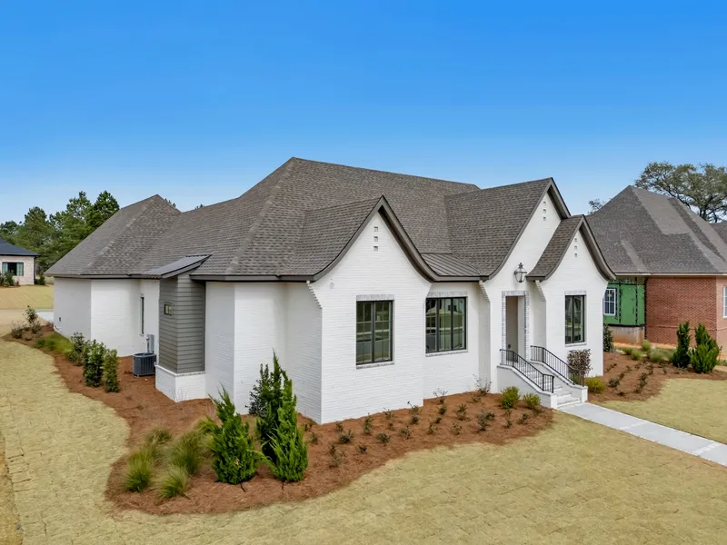 Angled exterior view of a white home with curved roof gables