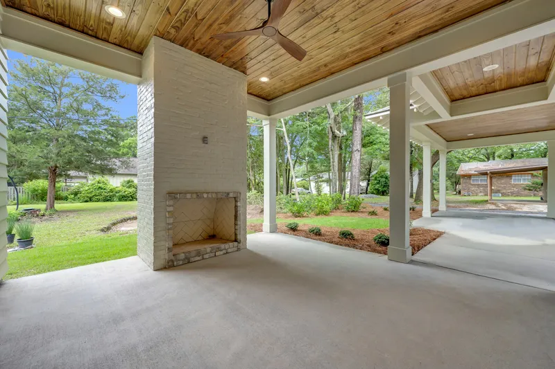 Covered outdoor seating area with a fireplace and a wood ceiling