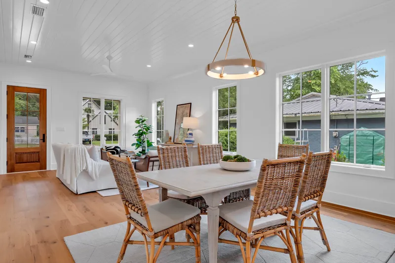 Dining and living area with pendant lighting and windows overlooking the garden